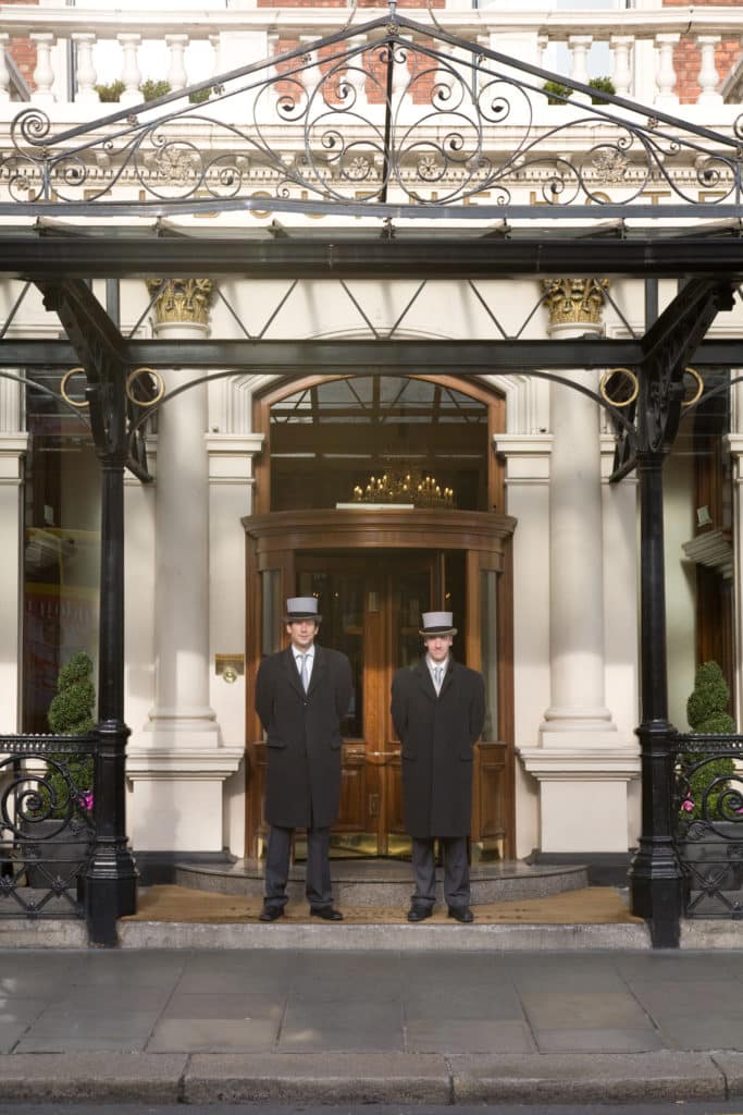The outside of the Shelbourne Hotel in Dublin, with two men in their distinctive uniforms ready to usher in guests