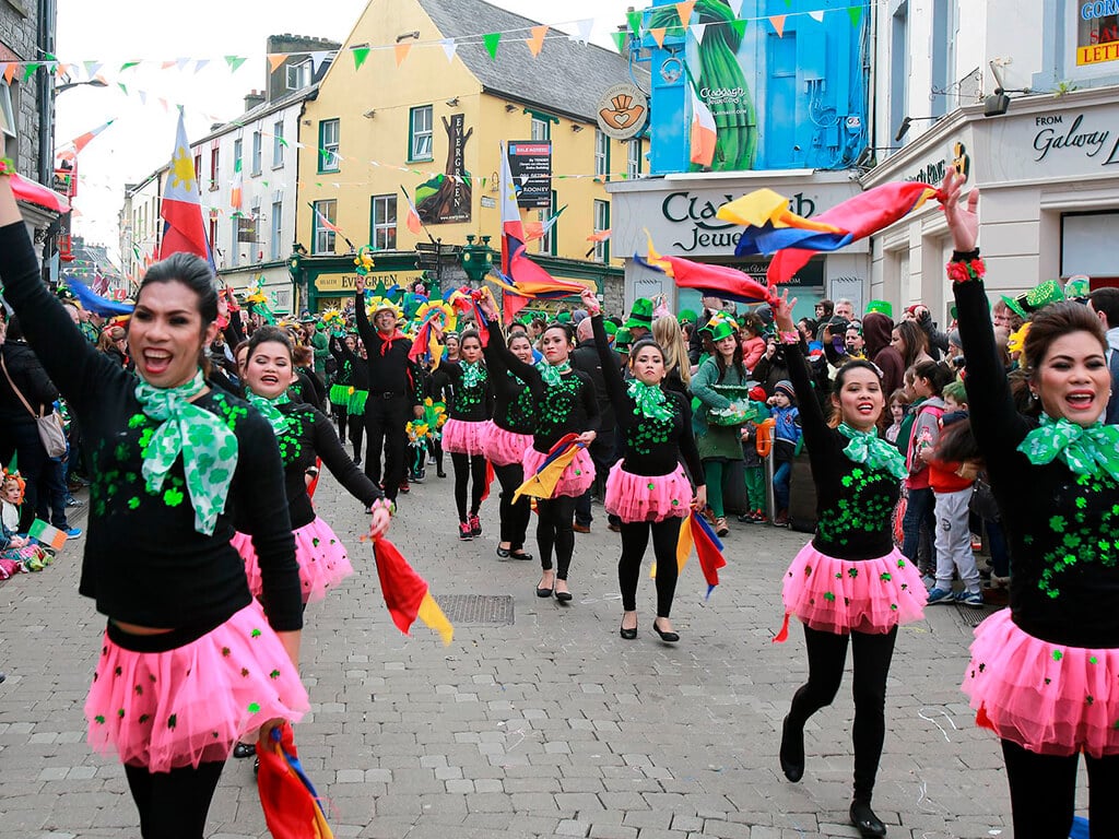 Dancers in pink tutu dresses and green scarves at Galway's Paddy's Day parade