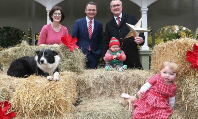 A photograph showing a dog, a child and officials who are announcing the return of the live animal crib in Dublin