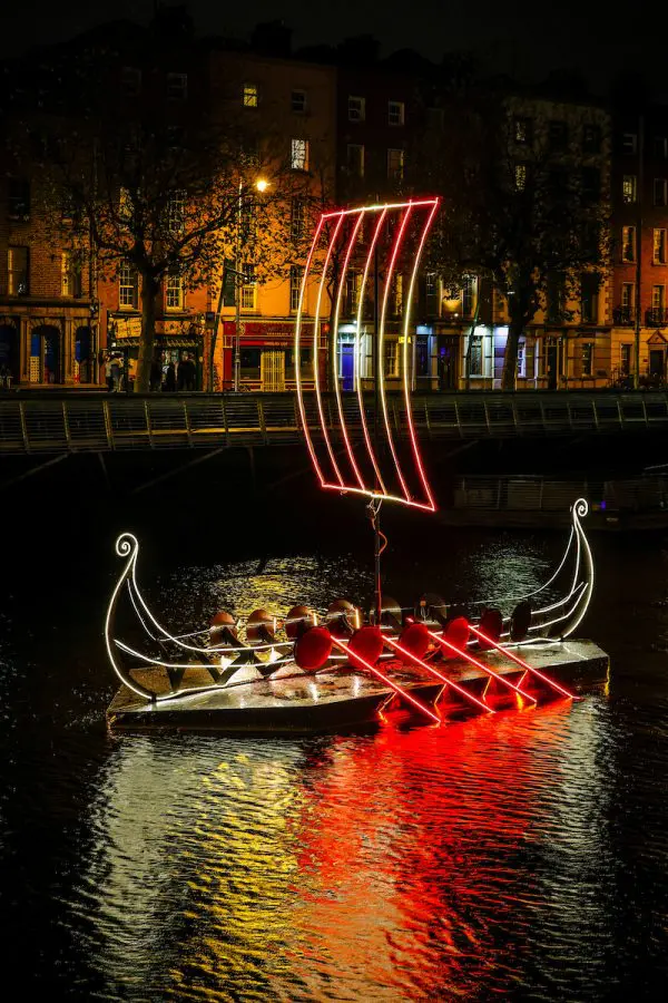 The new Viking boat winter and Christmas lights installation in Dublin - it shows a Viking ship lit up with lights and its reflection in the water