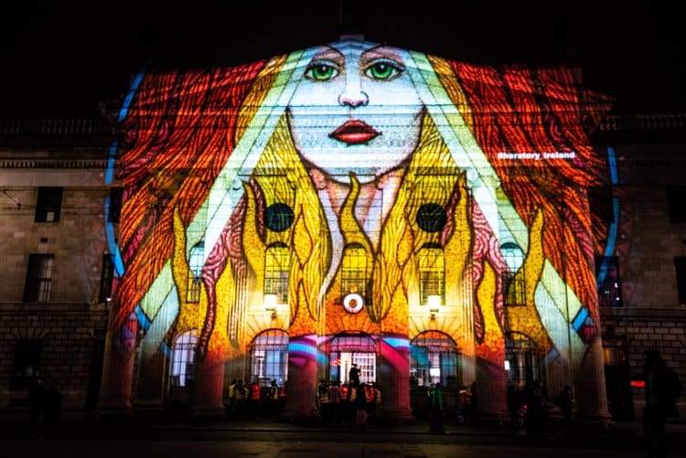 St. Brigid depicted in vibrant colours and lights and projected on a public building