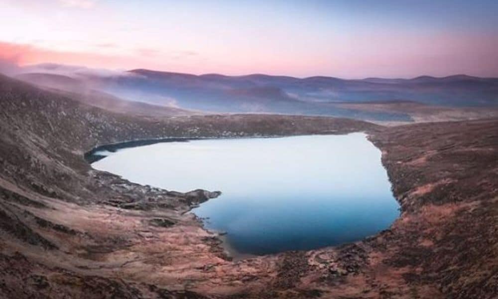 Photograph from official Twitter handle of Discover Ireland showing a heart-shaped lake with colour skies overhead and nestled among hills - perfect for Valentine's Day