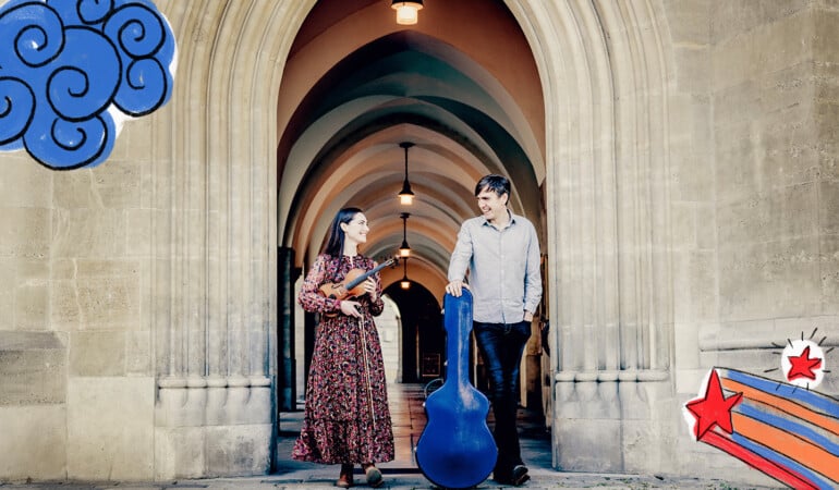 Musicians Zoë Conway and John McIntyre standing outside an arched doorway and passage, with musical instruments in their hands - posing for the Children's Festival promotions