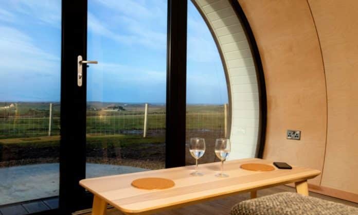 Luxury glamping pod with clear views of meadows and blue skies