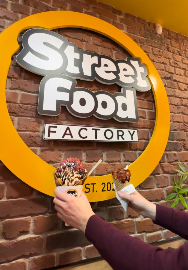 A brick wall with Street Food Factory logo 
