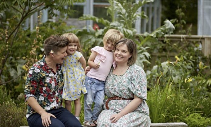 Erin and Jo with their children - dresses are in floral print and a child has a flower in hand