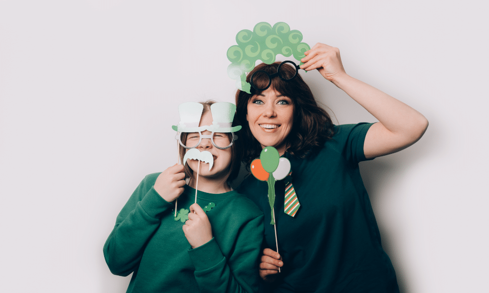 A mother and a her daughter dressed up in green with green masks and decorations for St. Patrick's Day