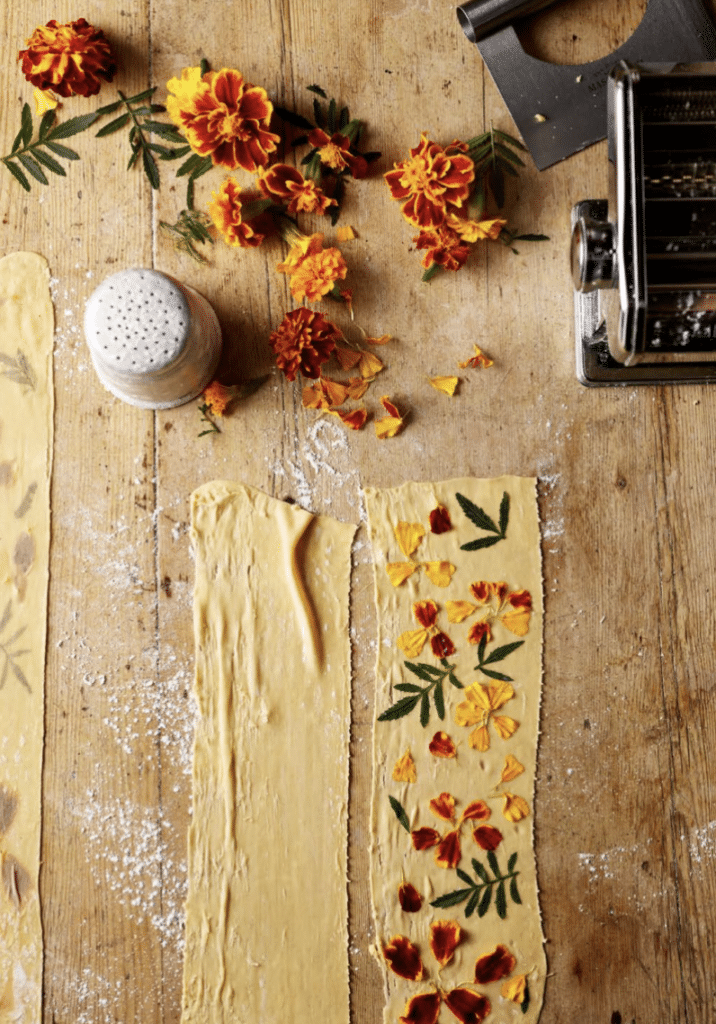 Marigold and pasta sheets laid out on a table 
