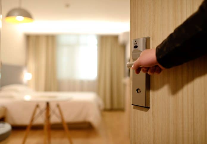 A man holds open the door to a hotel room - indicative of May bank holiday deal